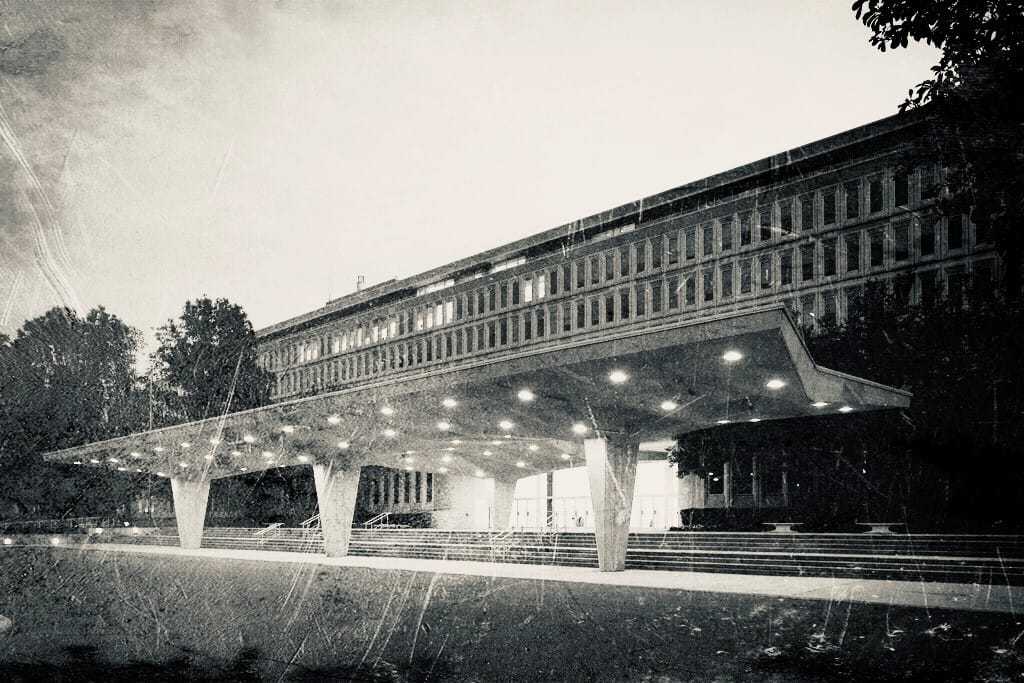 A scratched and faded black and white image of the entrance of the CIA Headquarters building.